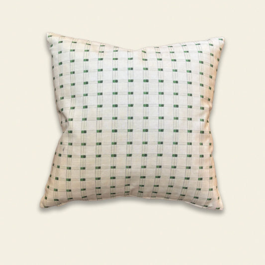 A square decorative throw pillow with a white base and a green grid pattern, shown against a solid light beige background.