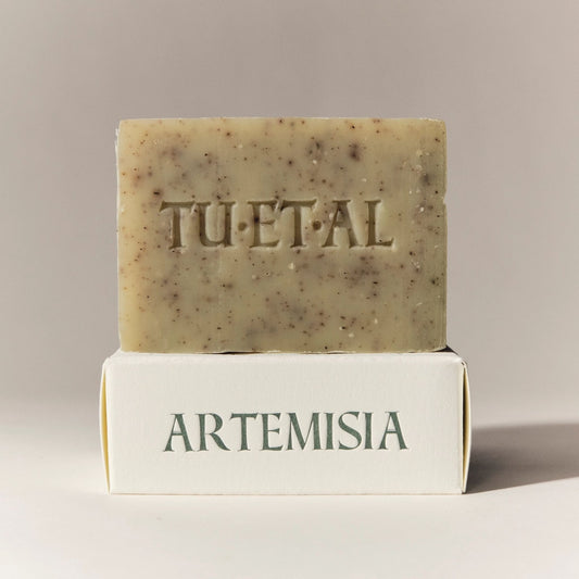 Bar of tan soap with brown spots with TU.ET.AL branding on a beige box that says Artemisia