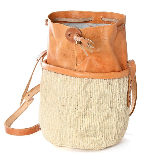 A flat-bottomed woven basket purse with a tan leather trim, an open leather top, and leather straps.