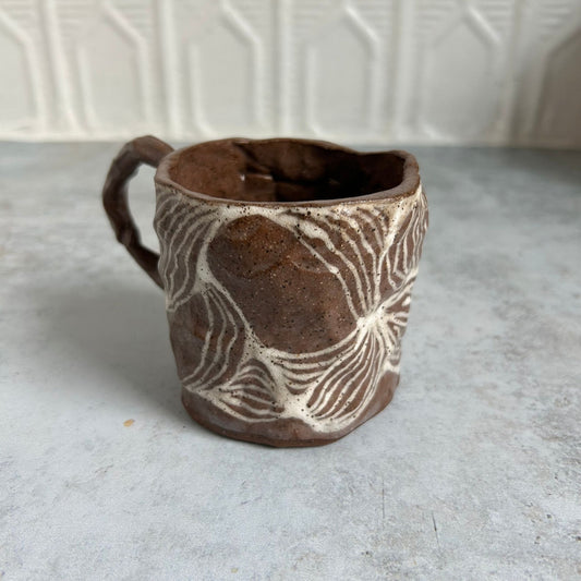 A brown mug with a white line pattern.