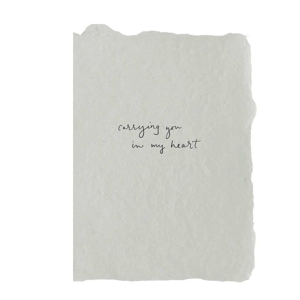 Handmade paper with black letterpress, features handwriting on the front that reads carrying you in my heart