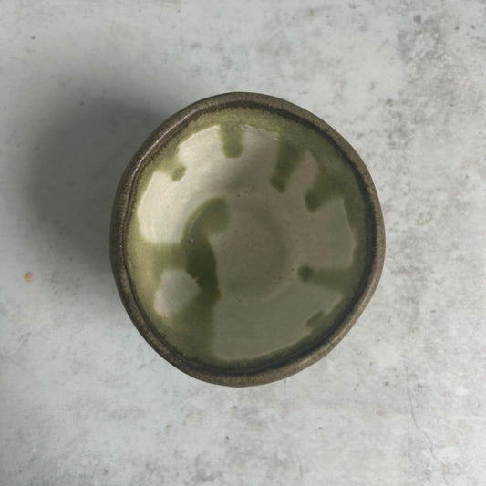 The inside of the cup, its a white base with green glaze drip from the top.