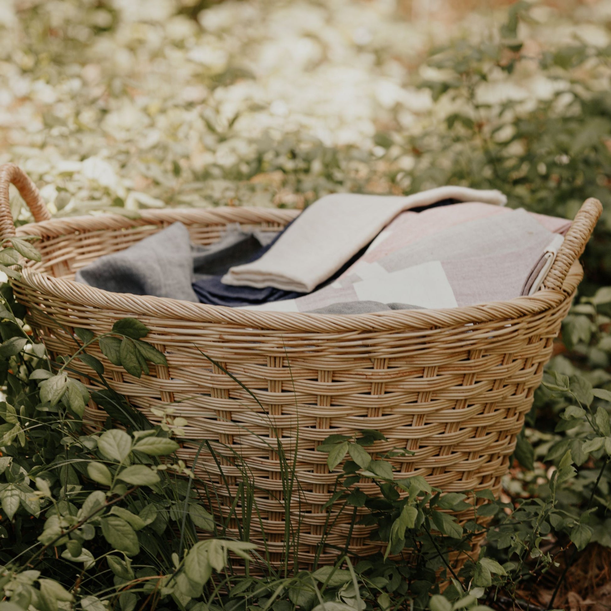 rattan laundry basket filled with linens in the woods