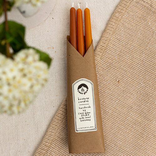 10-inch tall smooth taper candles made with locally-sourced beeswax, cotton wicks, and natural dye in red, orange and yellow