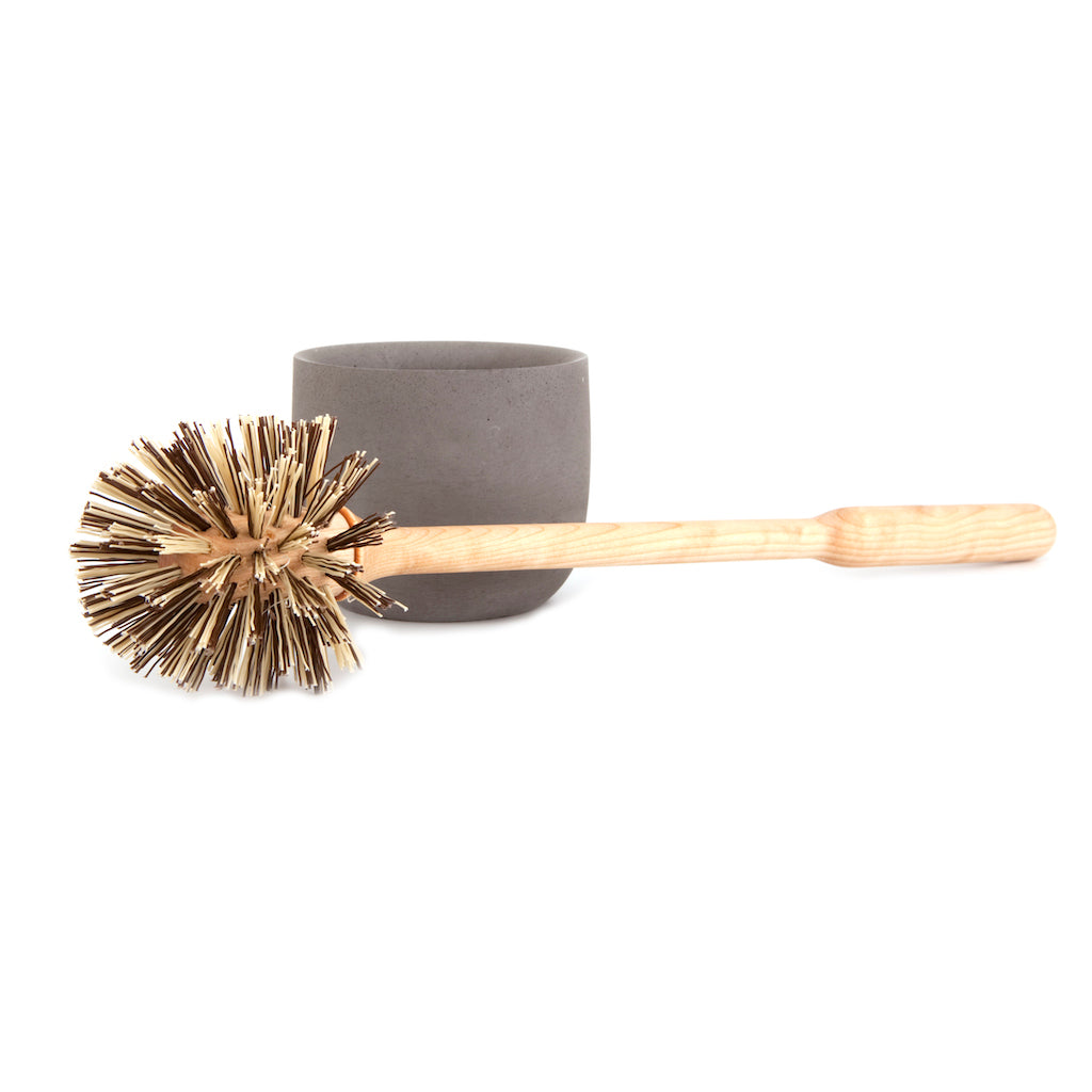 toilet brush with an oiled birch handle and polypropylene bristles alongside concrete storage cup