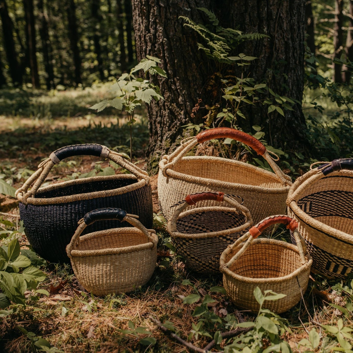 Large and small Bolga baskets shown outdoors in black, natural, and patterned
