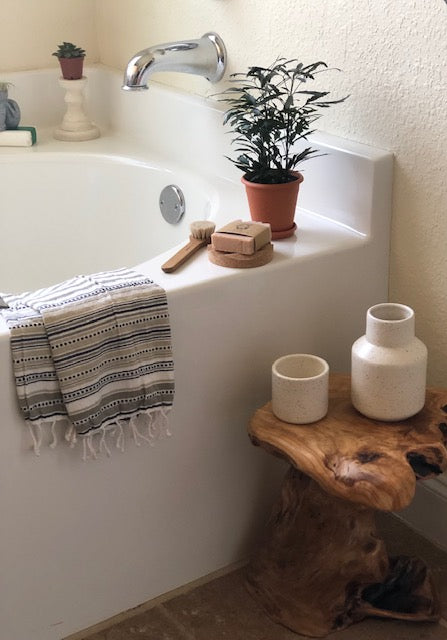 4.5 - 5 ounce moisturizing hand and body bar soap with essential oil blend in the scent Calm shown on bathtub with wash brush