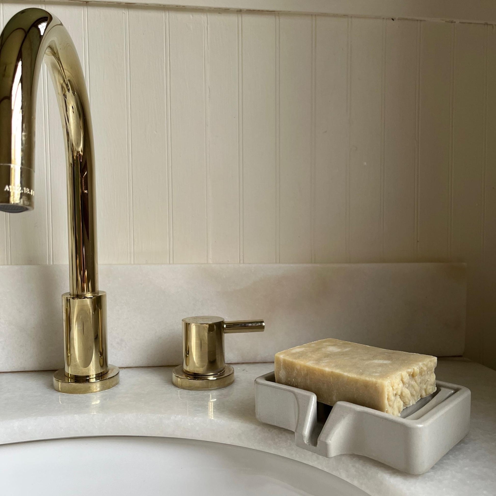 Concrete Soap Dish with Drain next to a sink with soap on it