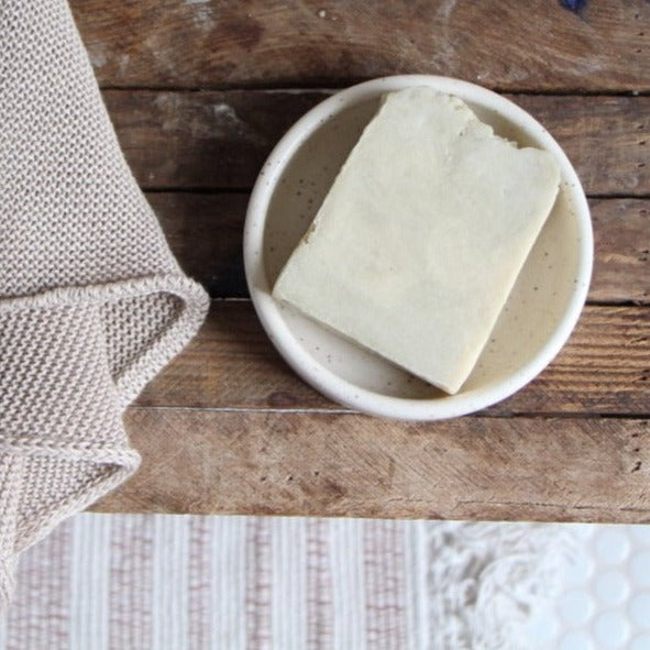 4.5 - 5 ounce moisturizing hand and body bar soap with essential oil blend in the scent Forest shown in soap dish