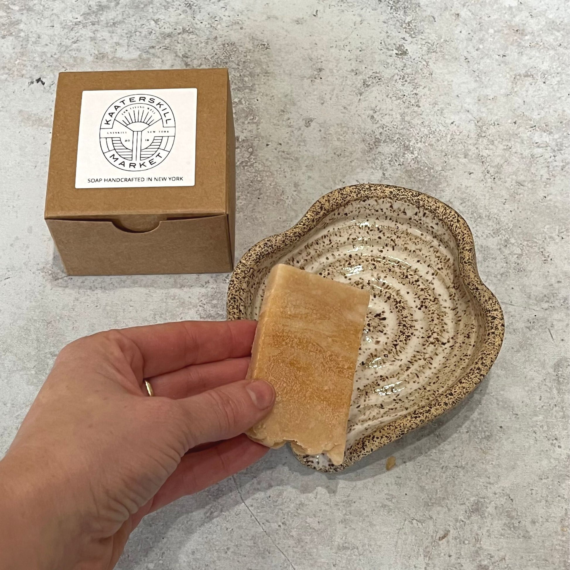 Individual hand soap in use shown with ceramic soap dish