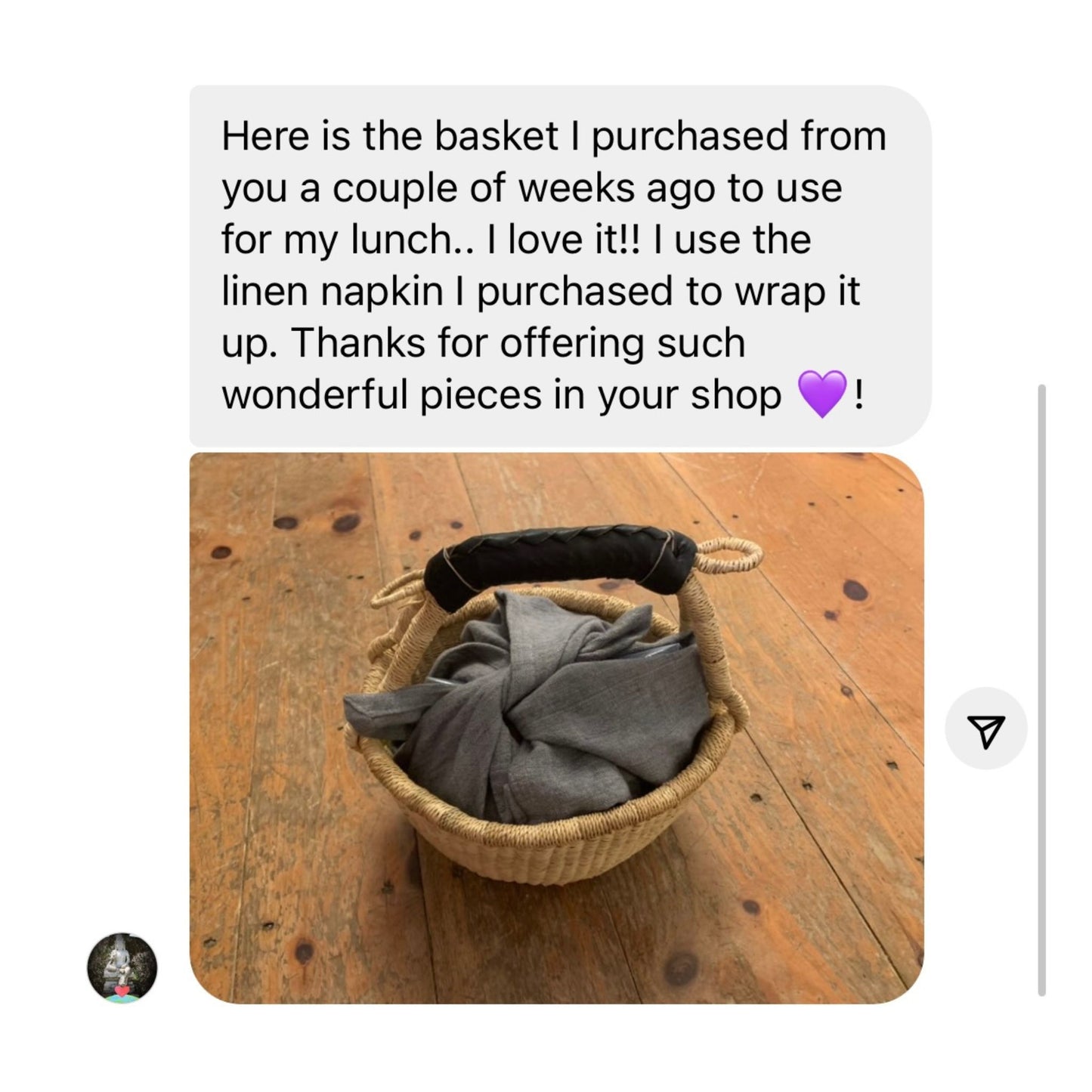 A text with a picture of a mini round bolga basket with a black leather handle holding linen napkins.