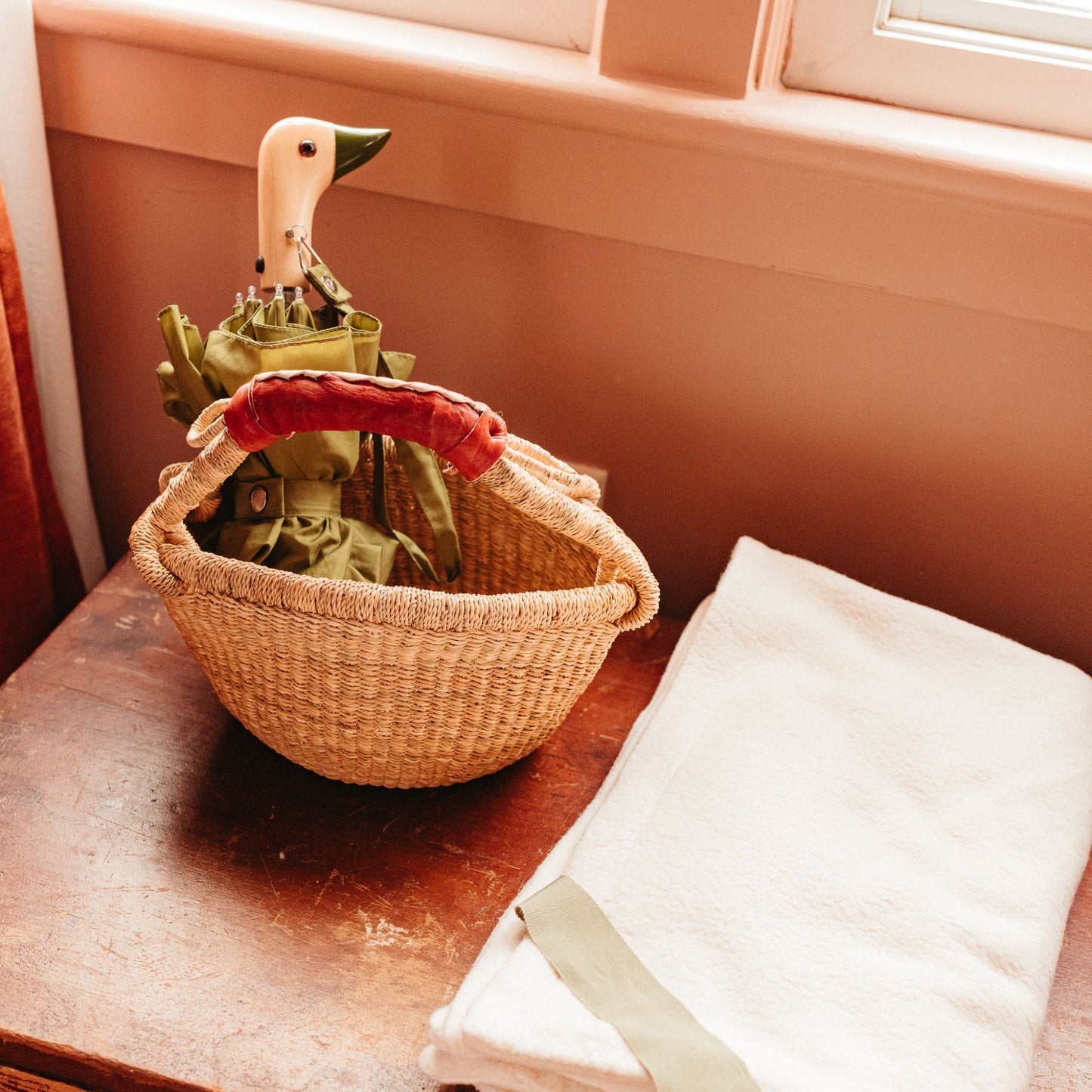 Mini bolga basket holding an umbrella on a table