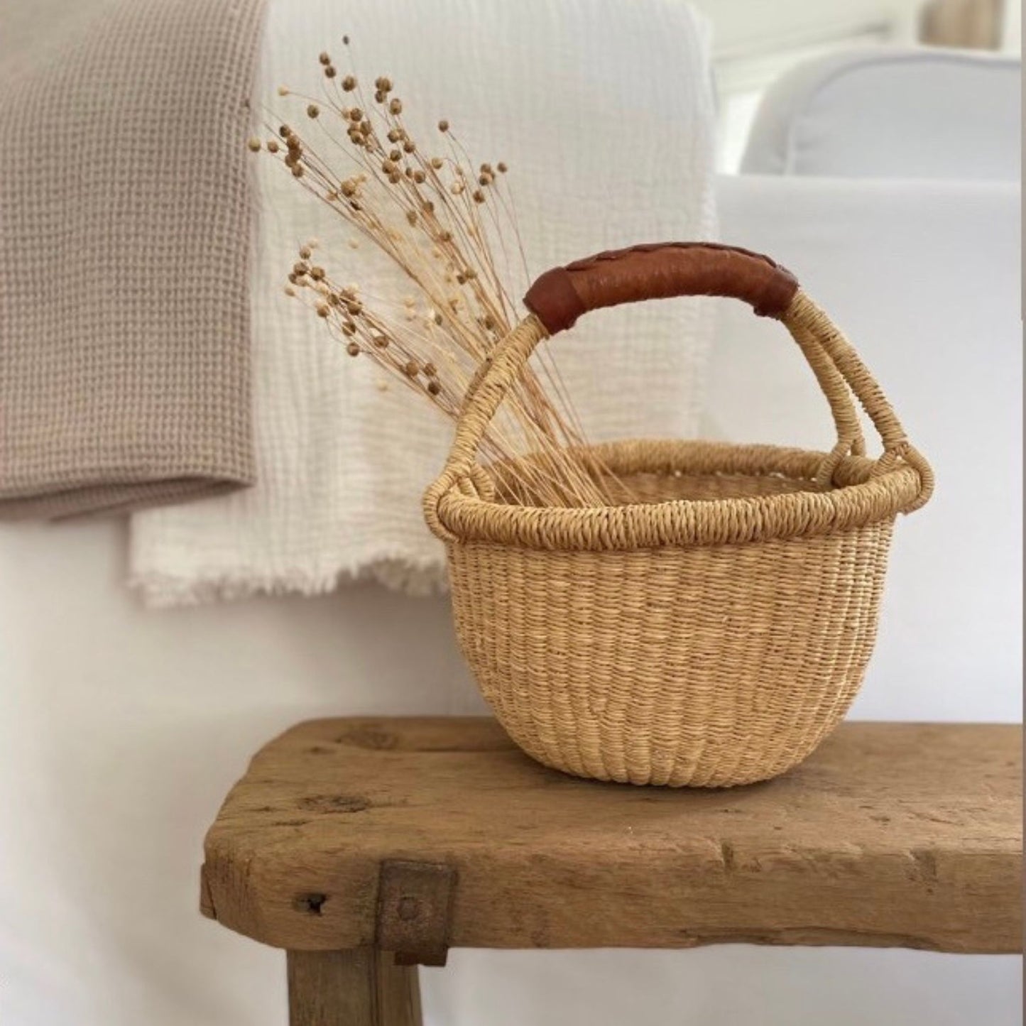 basket with dried flowers on a bench