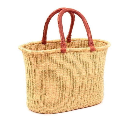 A woven, oval bolga tote basket with tan leather handles.