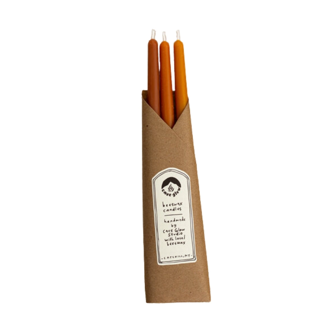10-inch tall smooth taper candles made with locally-sourced beeswax, cotton wicks, and natural dye in red, orange, and yellow