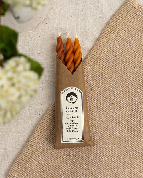 10-inch tall spiral taper candles made with locally-sourced beeswax, cotton wicks, and natural dye in red, orange and yellow