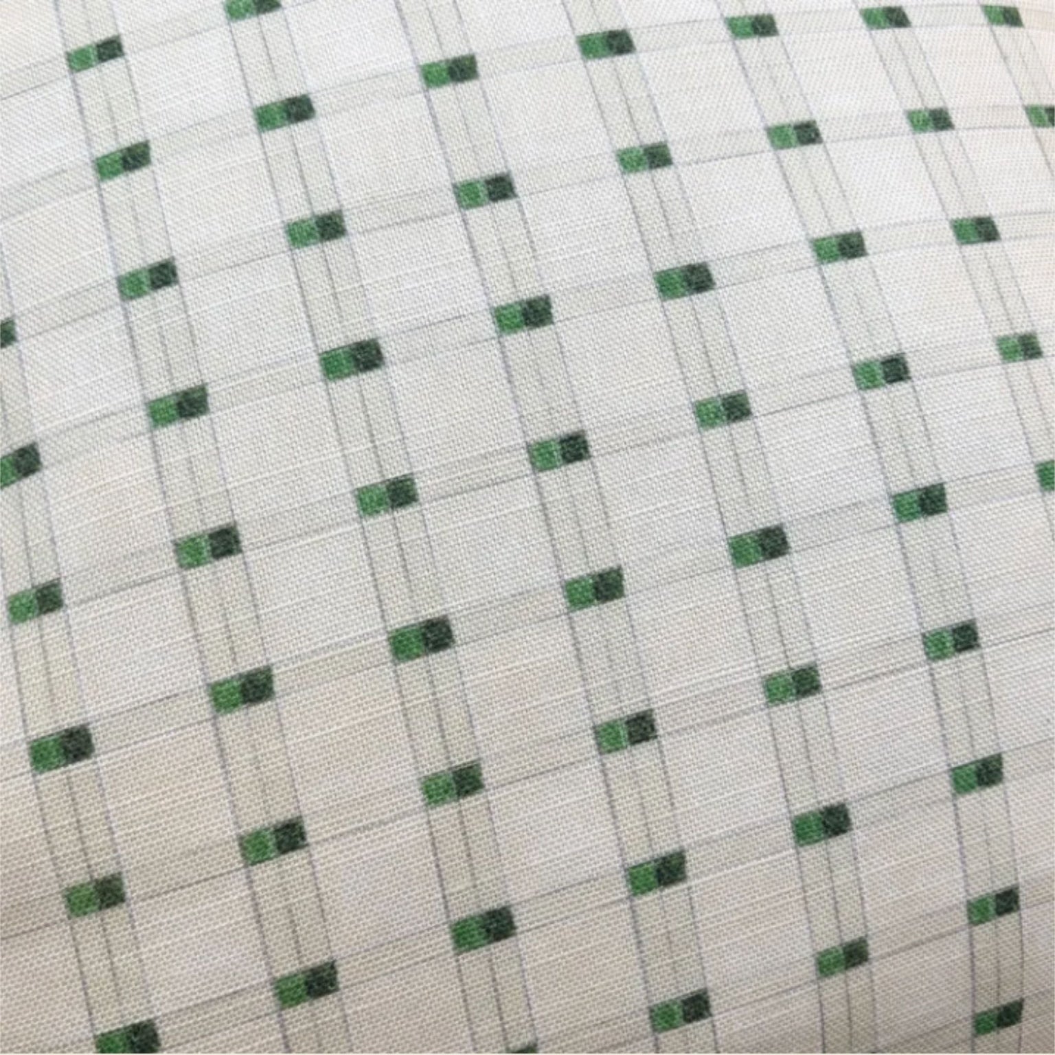 A close-up of a woven fabric with a white base, featuring a repeating pattern of small green squares outlined by thin gray intersecting lines.