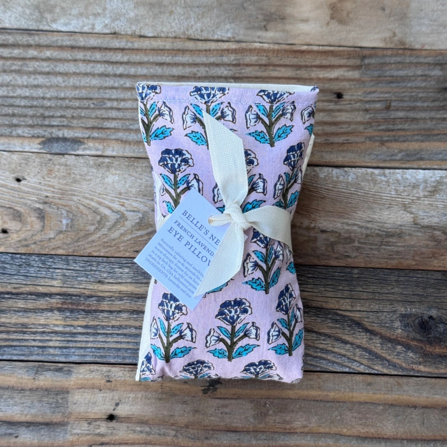 Fabric covered lavender pouch with floral design on a wooden surface