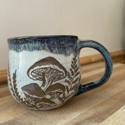 Ceramic mug with mushroom design on a wooden surface