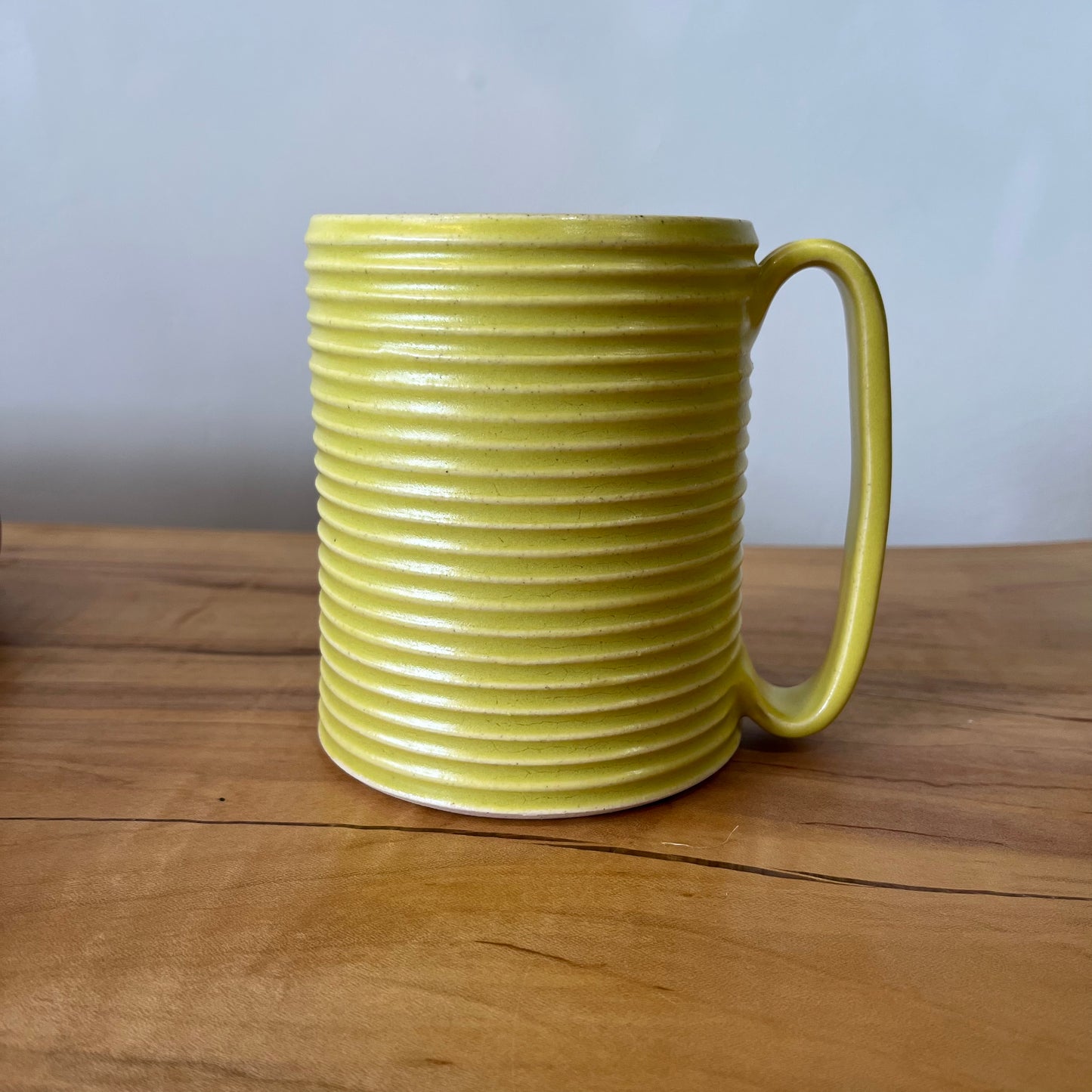 Oversized wheel-thrown ribbed ceramic stoneware mug with handmade glaze in yellow color