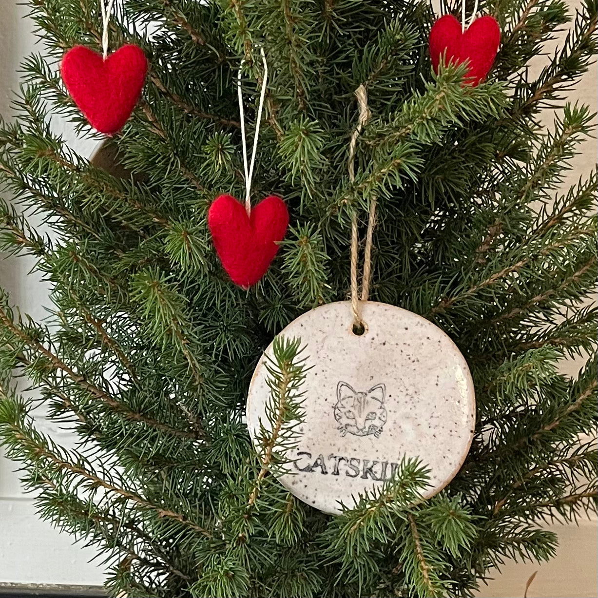 Ceramic Catskill Ornament hanging in a little tree with other ornaments