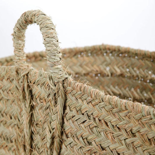 Close-up of a woven basket with a handle on a white background