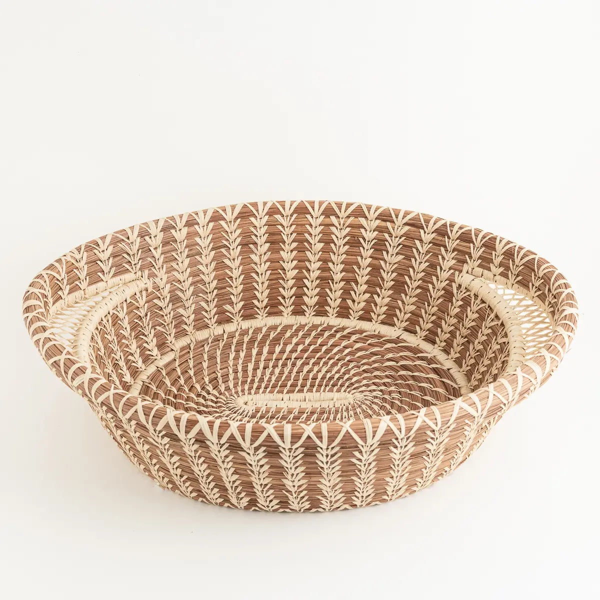 Large elegant pine needle basket features intricate lace-like raffia handles. Made of pine needles and pajón, a native grass found near Lake Atitlán in Guatemala. Handmade and fair trade.