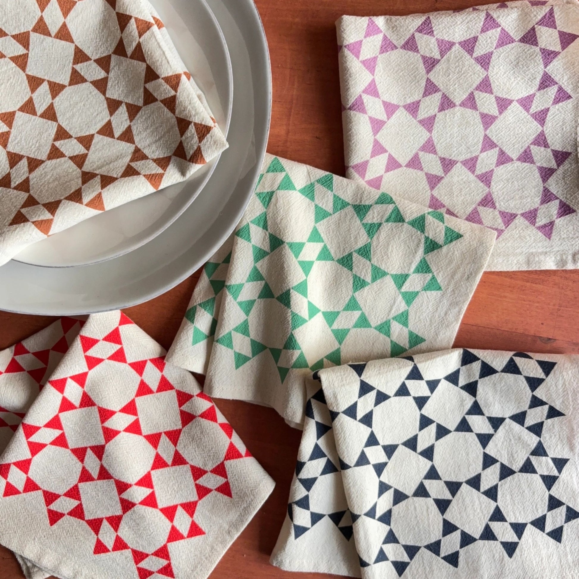 Set of geometric patterned napkins on a wooden surface