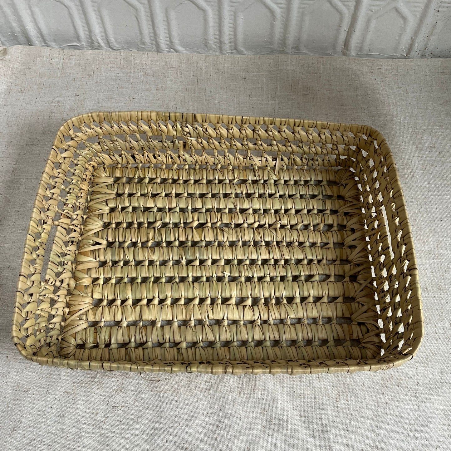 Woven rectangular basket on a textured surface