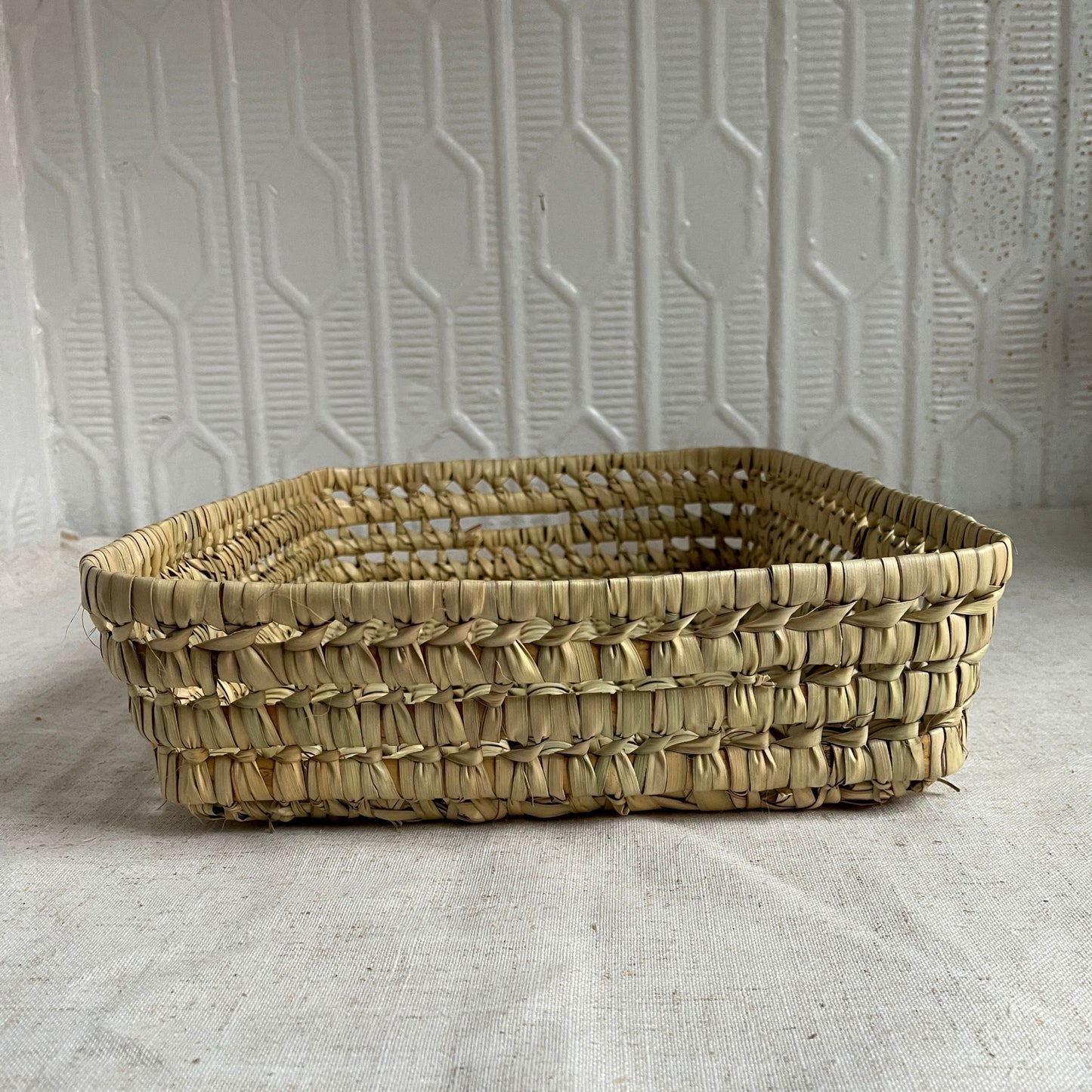 Woven basket on a textured surface with a neutral background