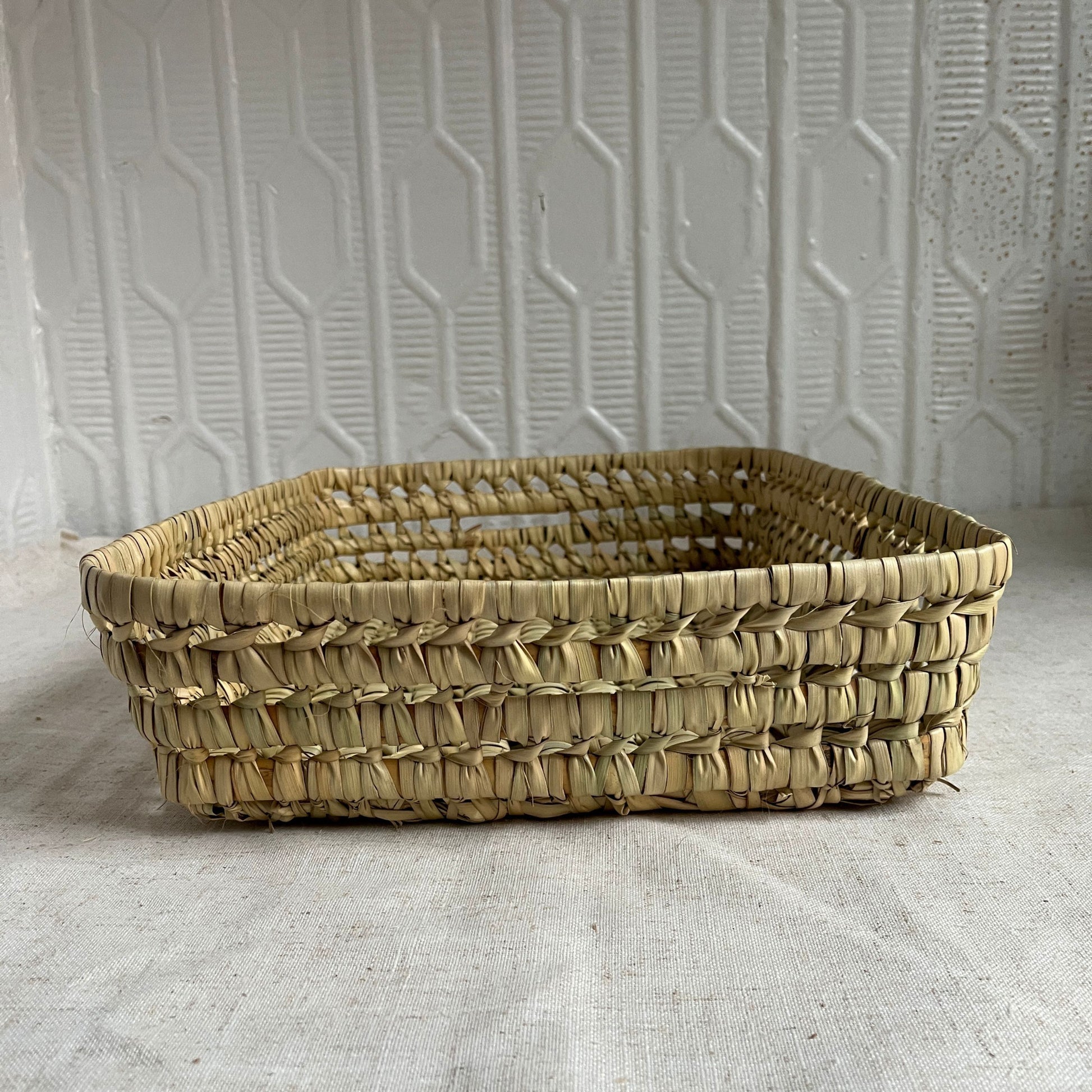 Woven basket on a textured surface with a neutral background