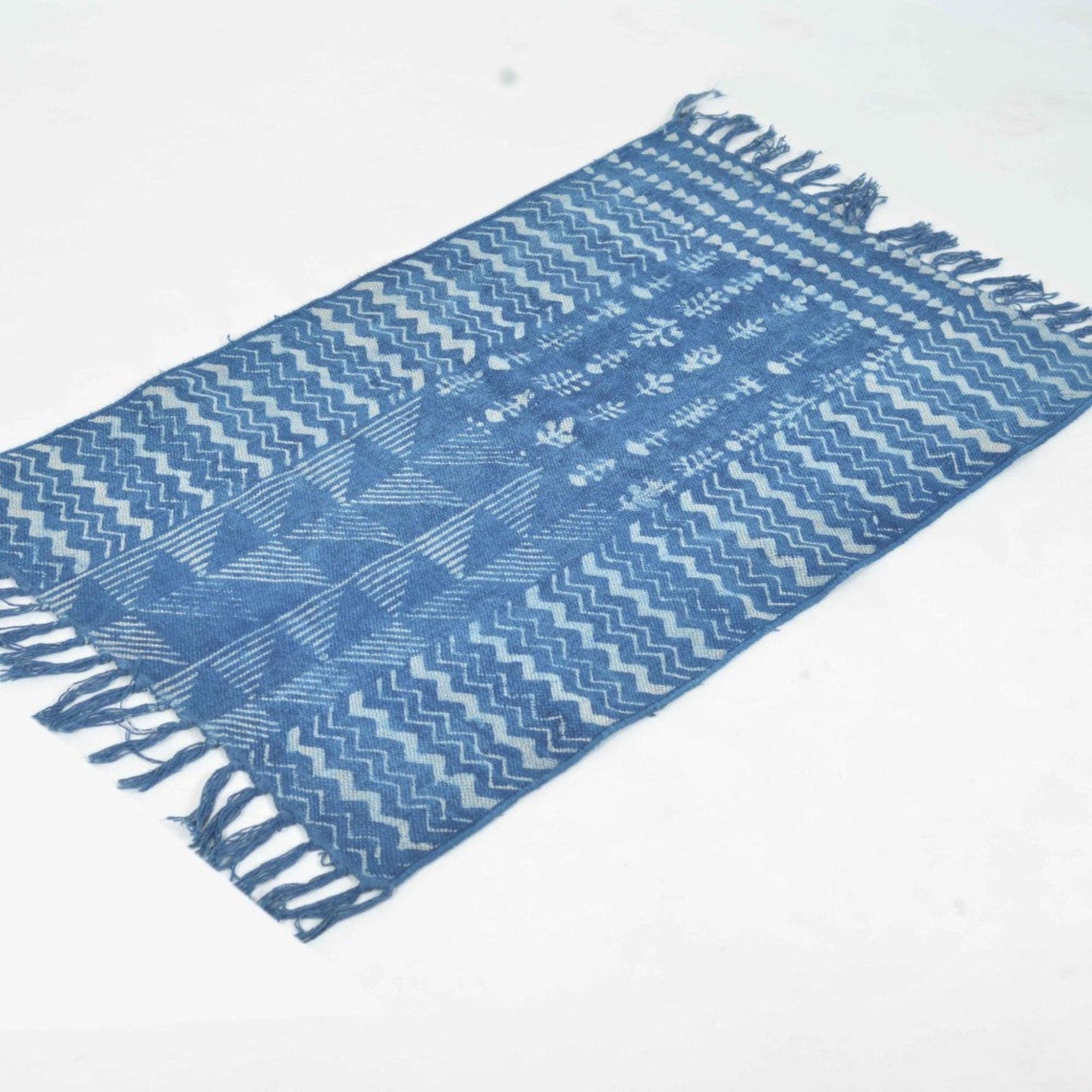 Hand Block Printed Cotton Rug in Indigo Blue with waves, triangles and flowers on it.