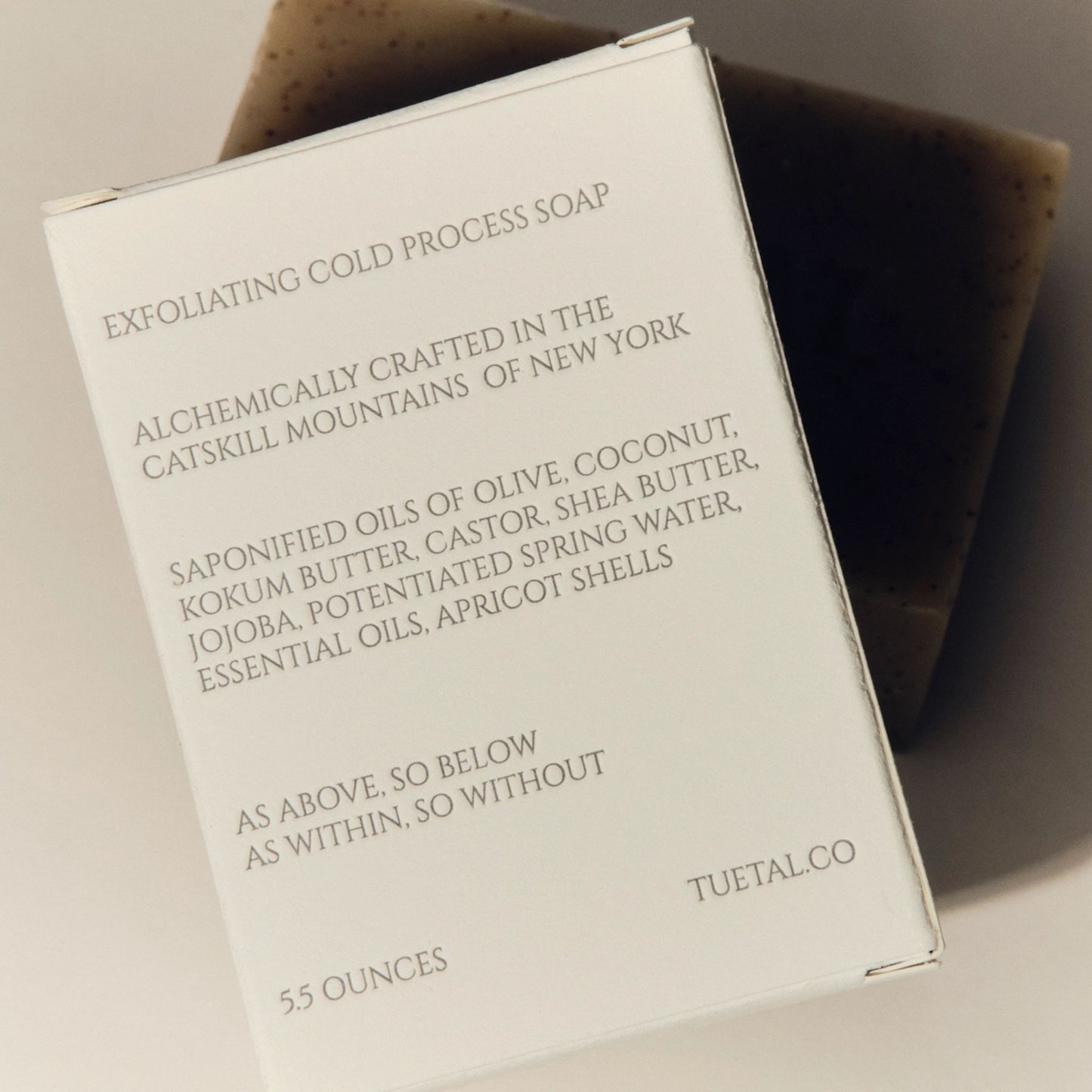 Exfoliating cold process soap packaging with text on a neutral background