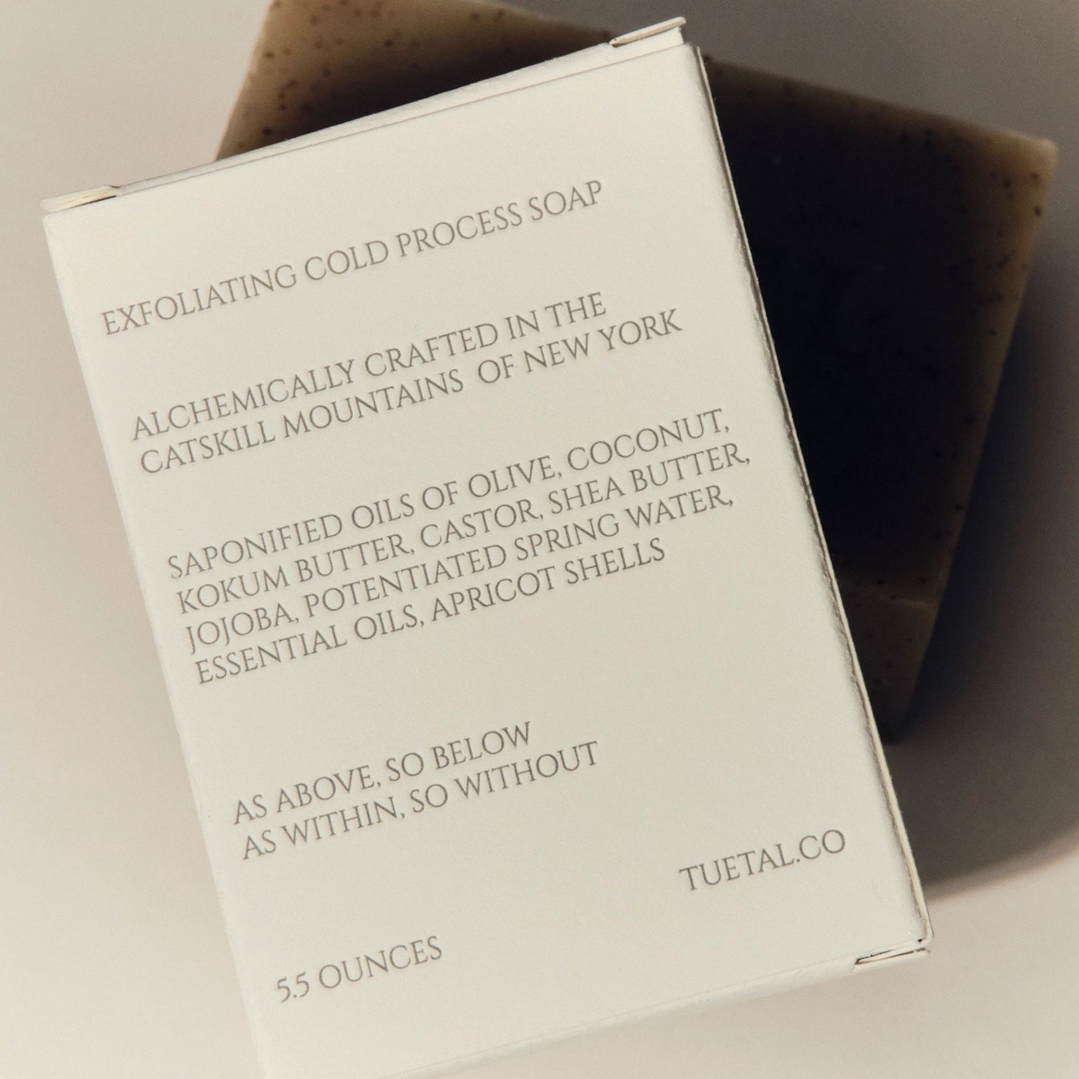 Exfoliating cold process soap packaging with text on a neutral background