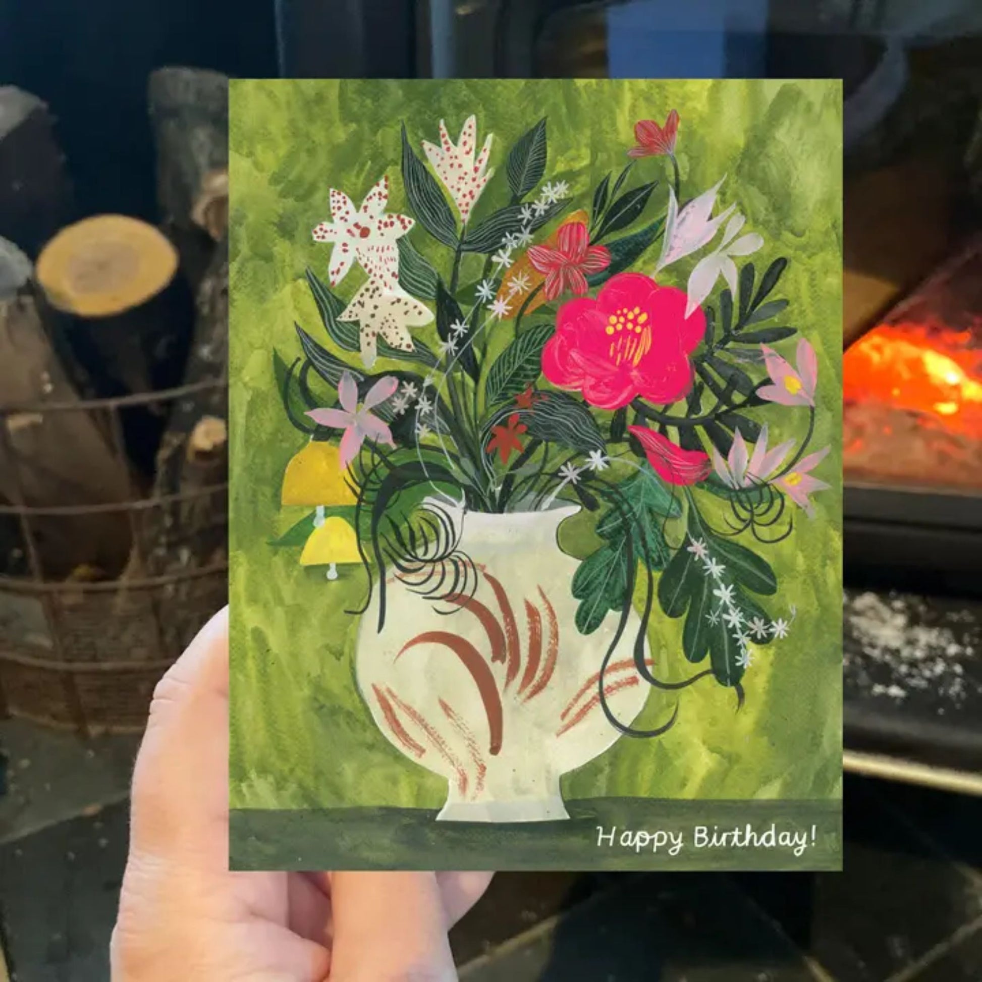 Handheld birthday card with floral design and 'Happy Birthday!' text.