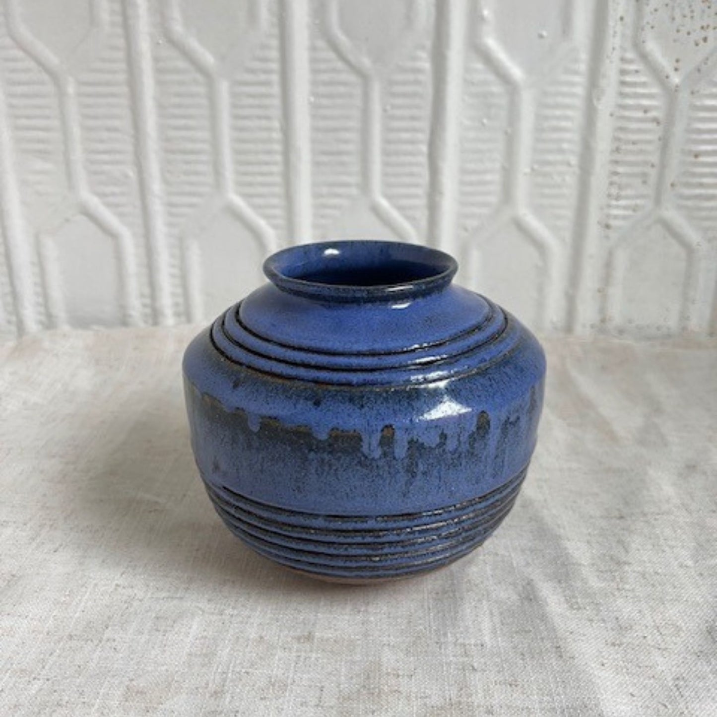 Blue ceramic vase with white background.