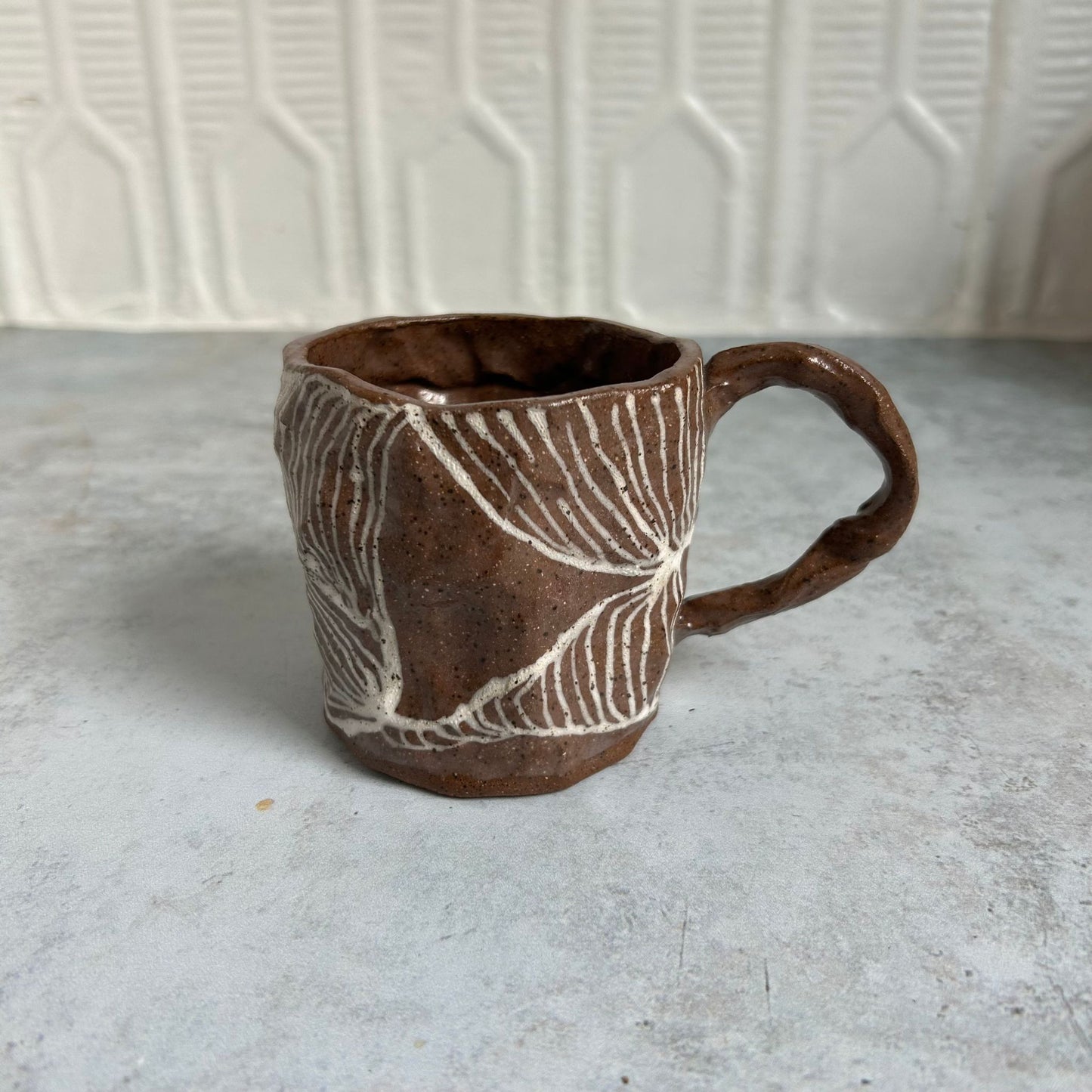 A brown mug with a white line pattern.