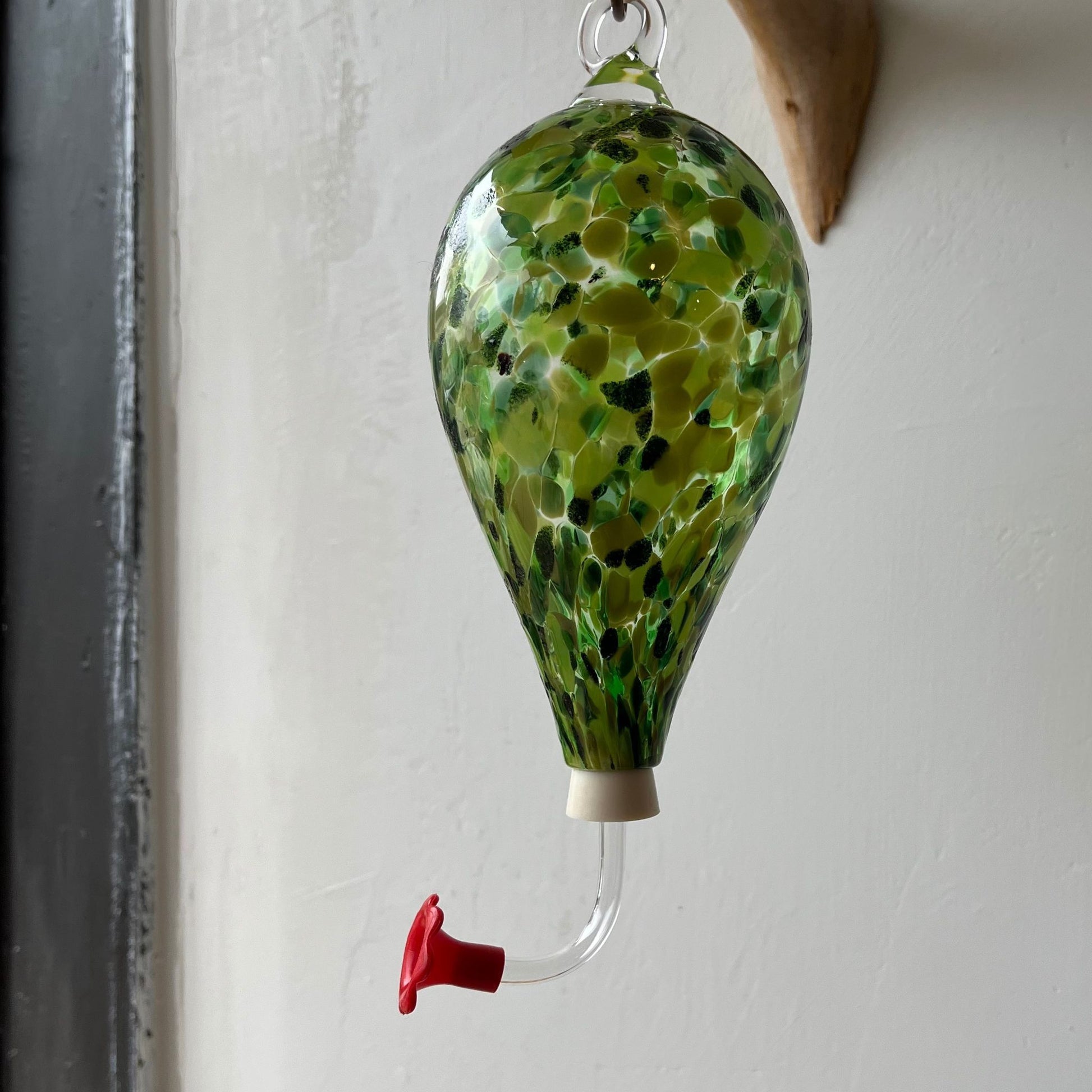 Green unique Glass Hummingbird Feeder.They are handblown glass made in the USA. The feeder tube is removable allowing for easy cleaning and refilling.