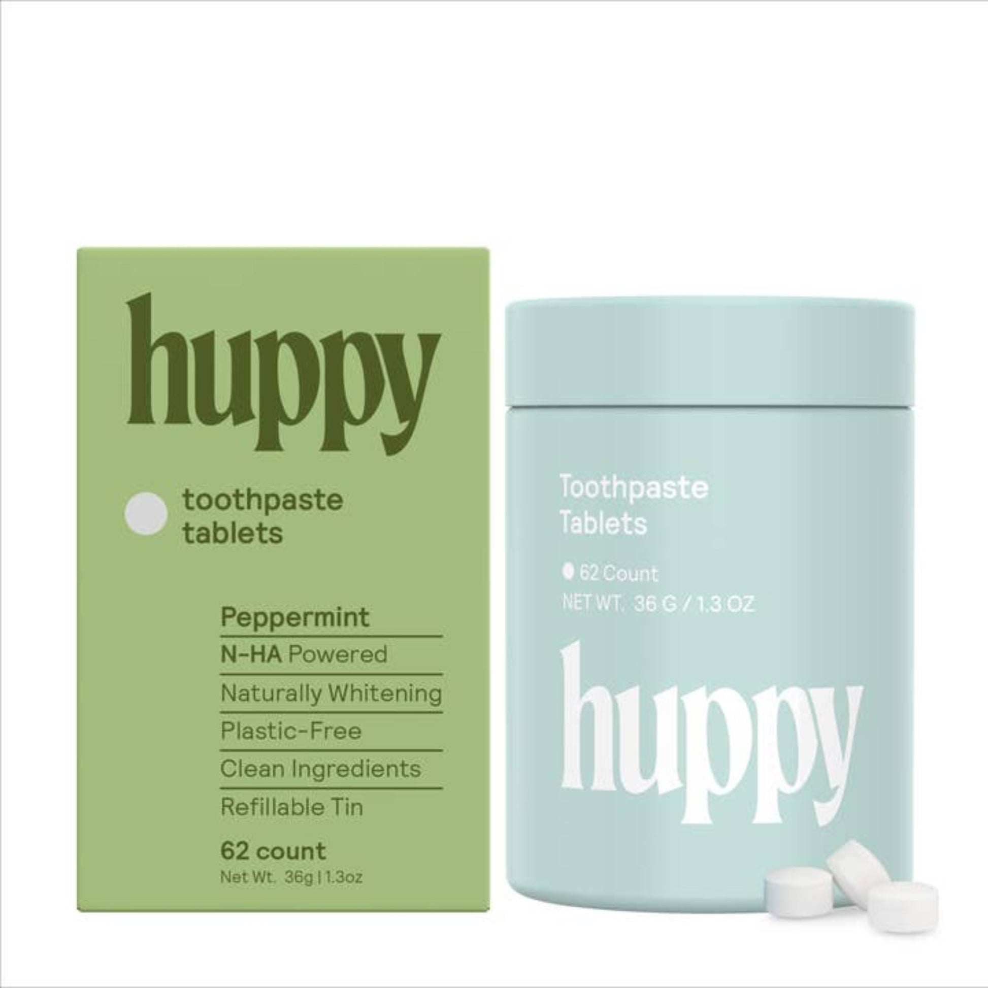 A green box with the "Huppy" logo and information about the tablets on it alongside the blue small tin the tablets come in and three tablets in front of it.
