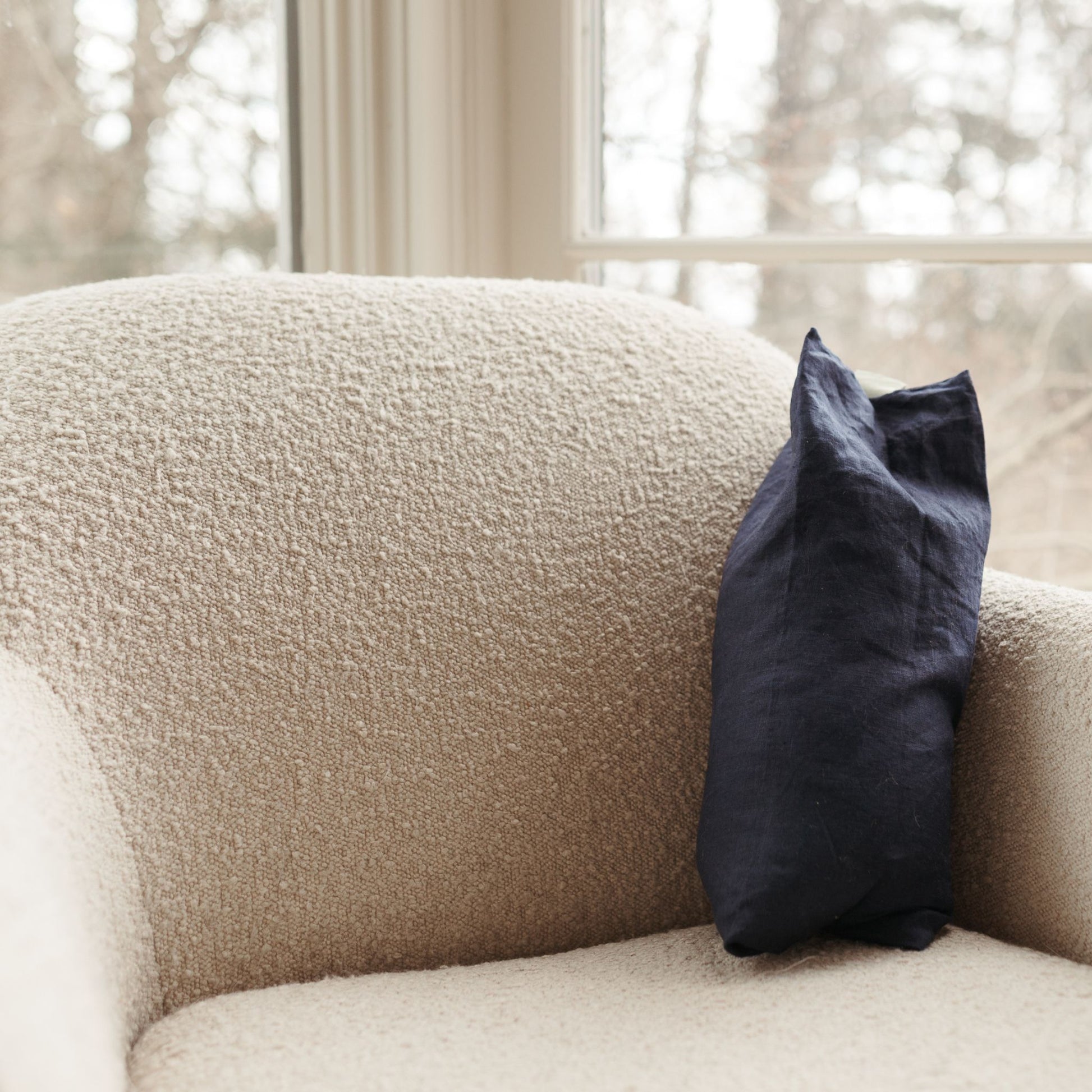 Buckwheat Pillow in indigo resting on a sofa. The cover is 100% linen.