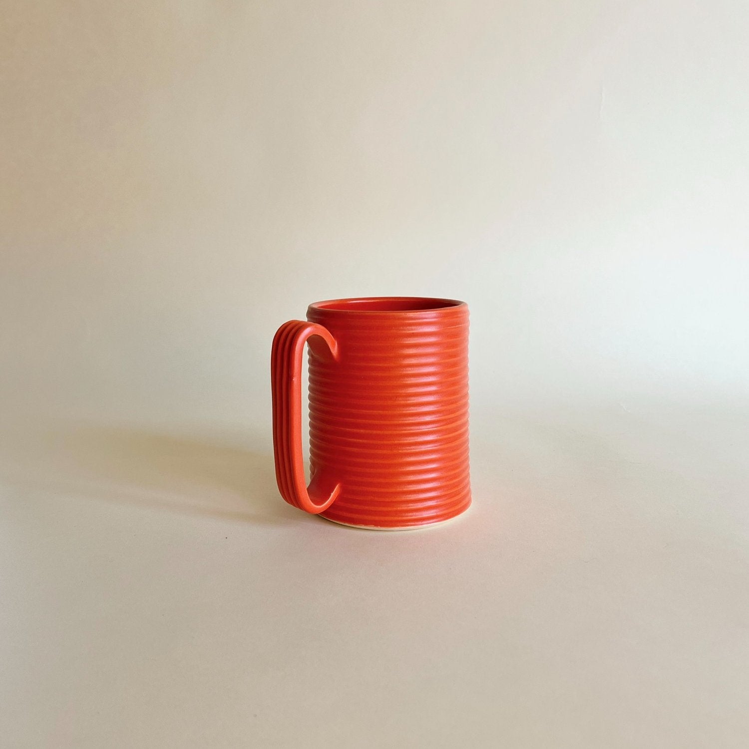 Oversized wheel-thrown ribbed ceramic stoneware mug with handmade glaze in red color