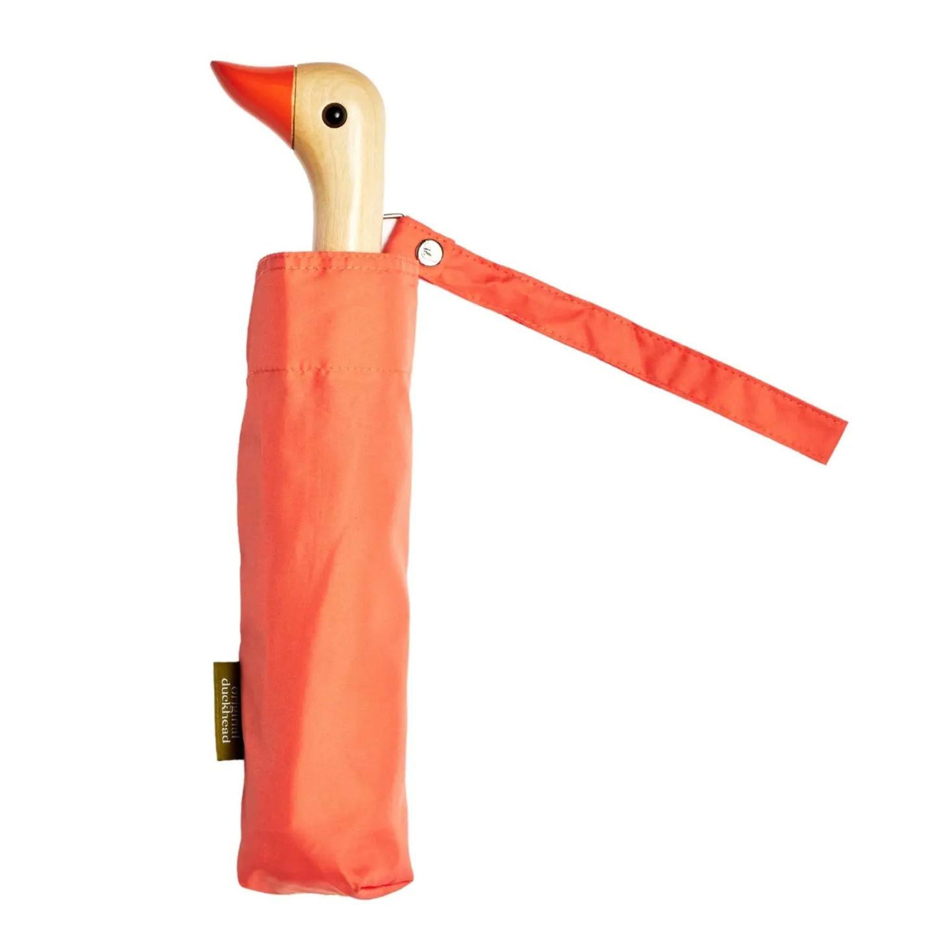 Compact umbrella in peach with birchwood handle in the shape of duck head