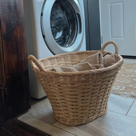 rattan laundry basket filled with linens in a laundry room