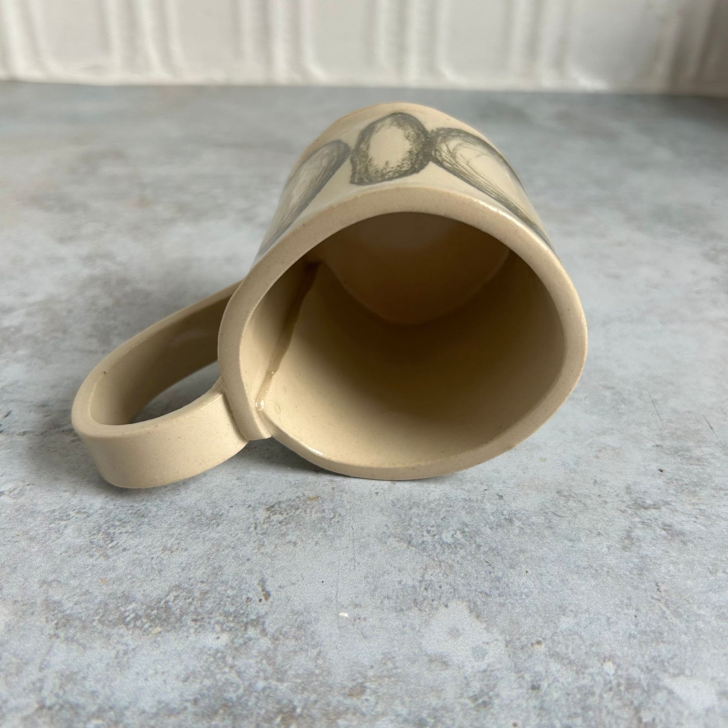 White mug with black drawn circles all around it.