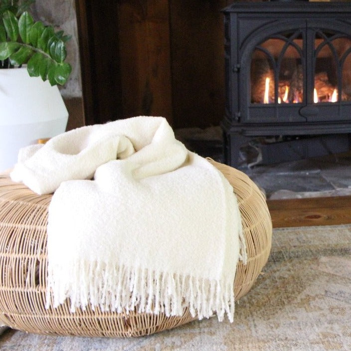 Blanket on a seat cushion in front of a fire place