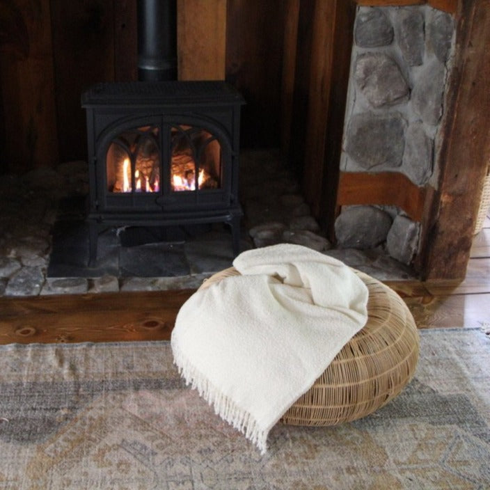 Blanket on a seat cushion in front of a fire place