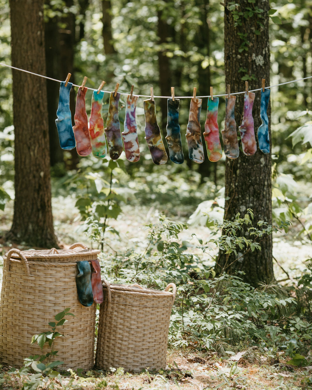 Lidded rattan storage baskets with handles shown in use outdoors with clothesline