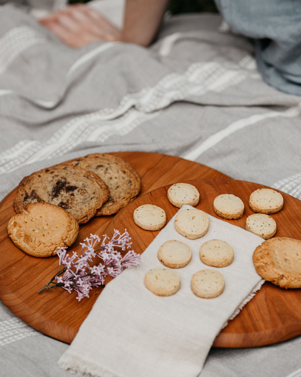 Large and medium circular cutting boards in cherry wood shown displaying an assortment of cookies