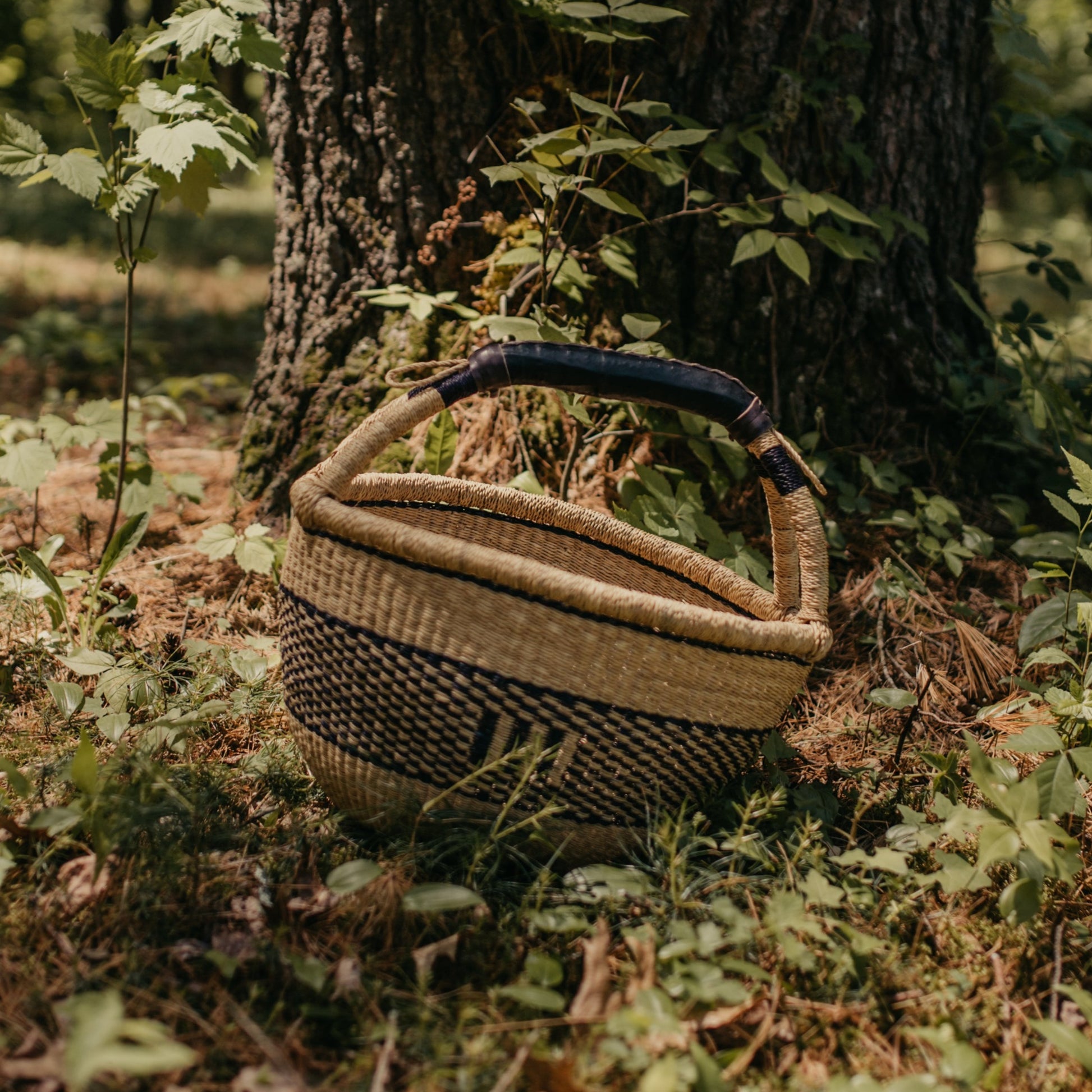 Large indigo and natural geometric patterned Bolga basket shown outdoors