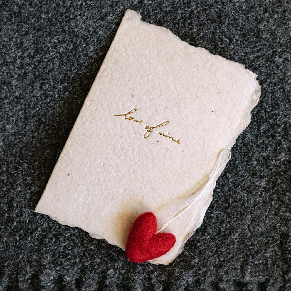 Handmade paper card with letterpress ink, message on front reads: “love of mine"
